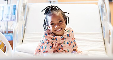 Little girl smiling in hospital bed