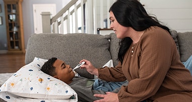 Mom checking son’s temperature at home