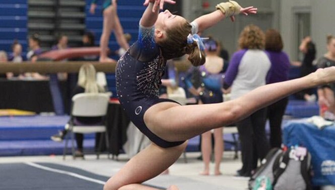 Carson, a teen athlete, competes in floor exercise at local gymnastics competition