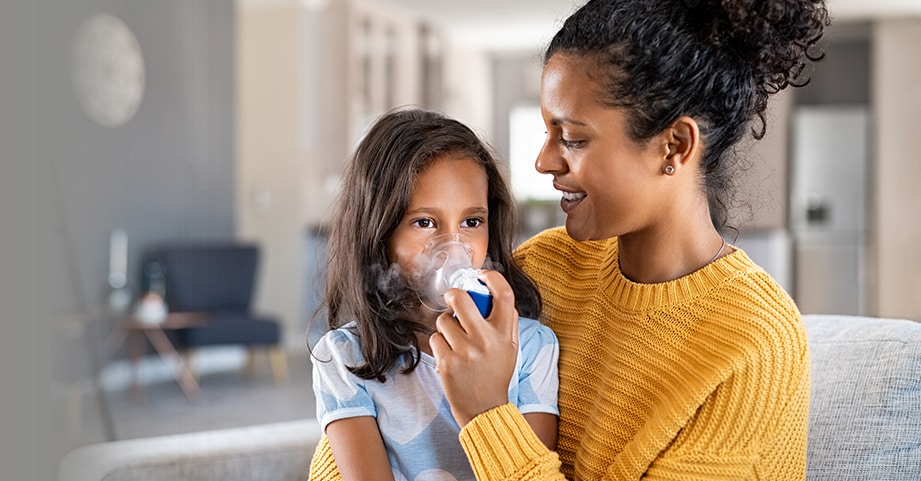 Mom giving daughter breathing treatment