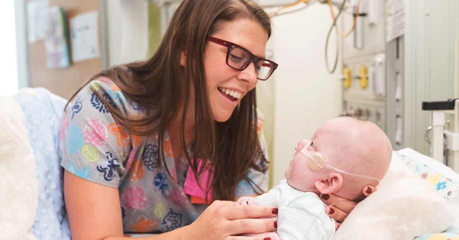 nurse holding patient in hospital bed