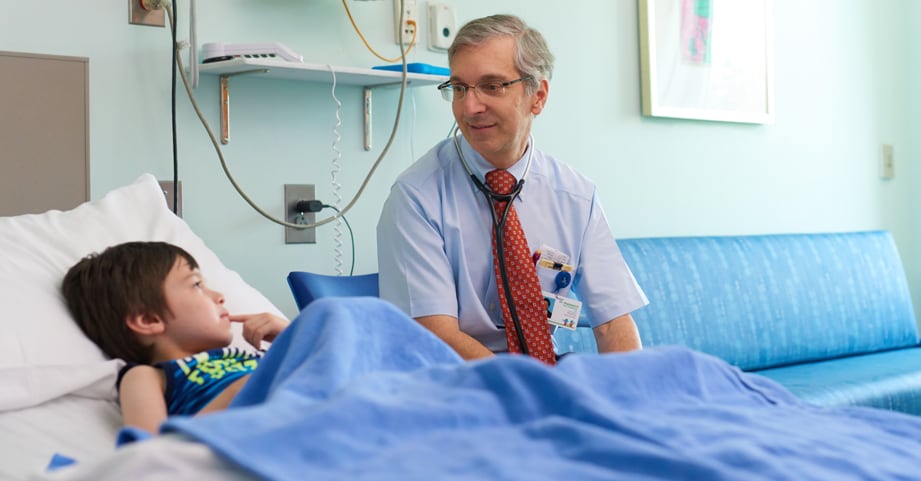 Doctor visits with diabetes patient at bedside.