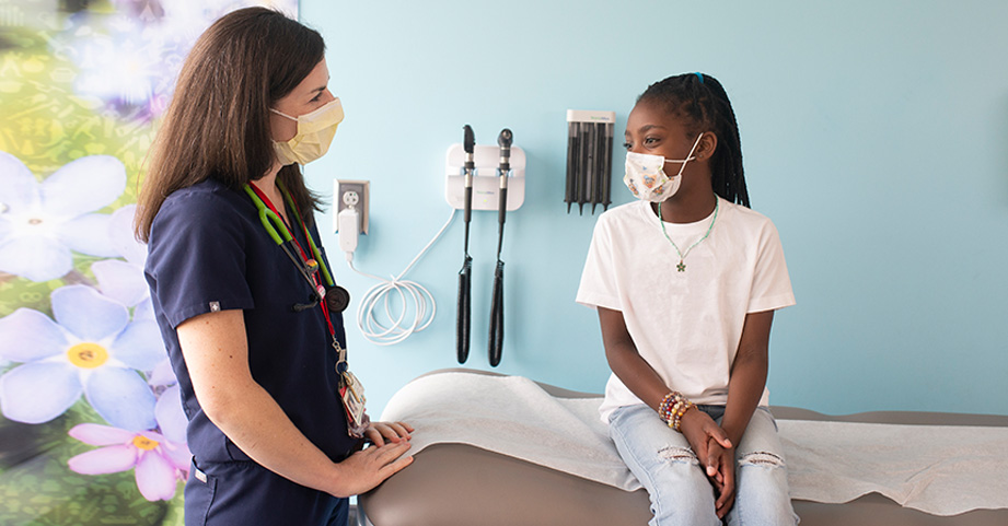 Doctor visits with diabetes patient at bedside.
