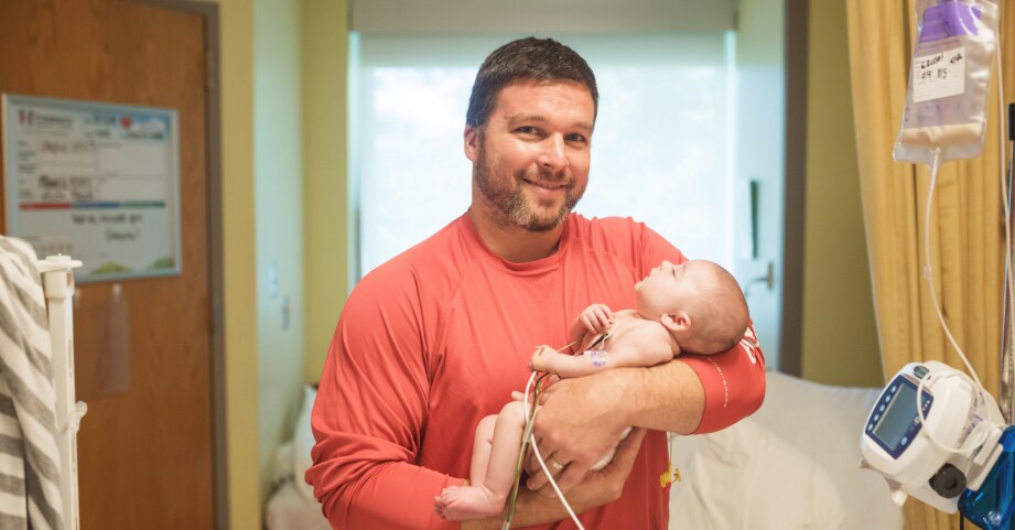 Father holding child after birth