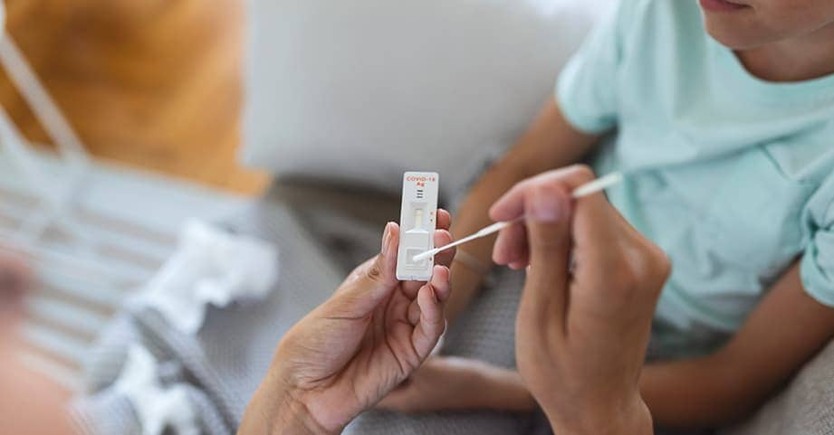 Mom giving a COVID rapid test to her child at home