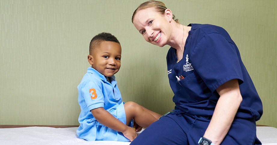 Dr. Flanagan smiles in clinic with hip surgery patient.