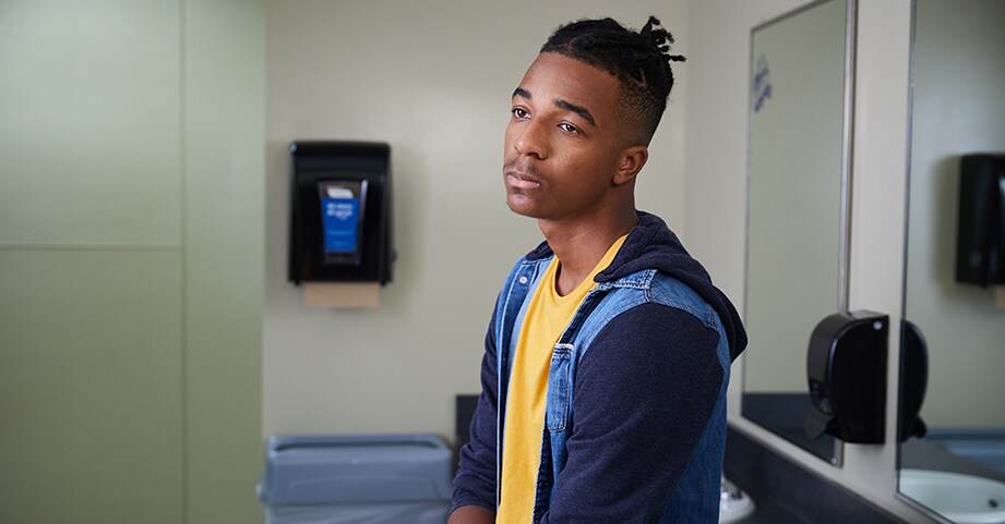 male teen standing in front of mirror