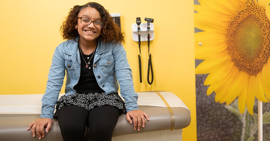Teen girl sitting on exam table in clinc
