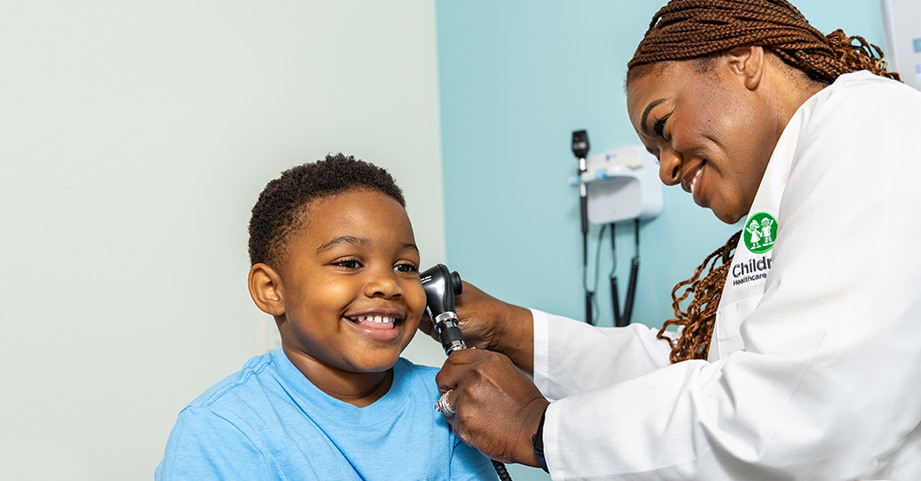 Toddler boy having ears checked by pediatrician