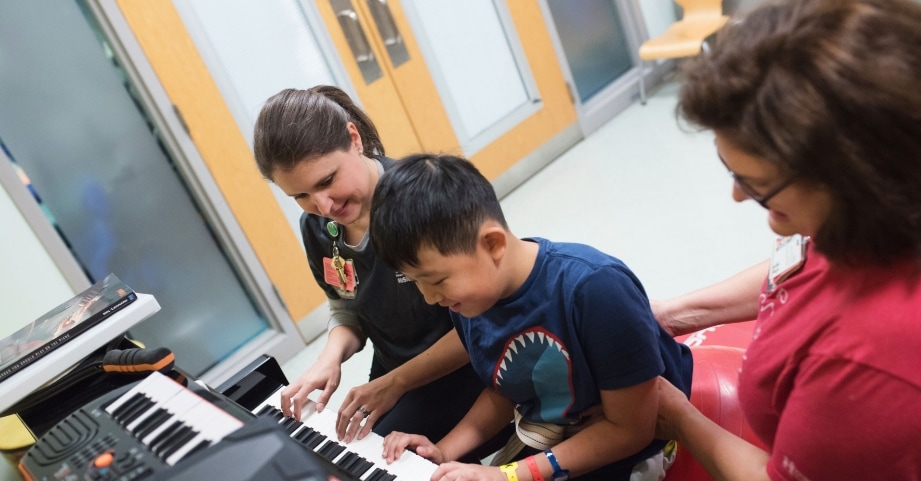 A child plays the piano while participating in music therapy at the Inpatient Rehabilitation Program at Children’s Healthcare of Atlanta.