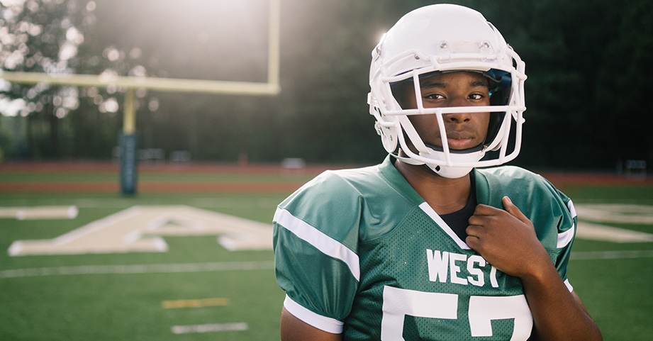 Teen football player on field before game.
