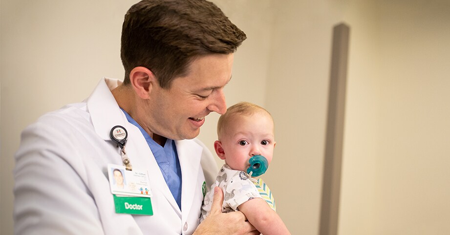 Dr. Clifton holds a baby patient before  surgery.