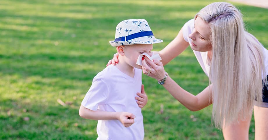 Mother helping child blow nose