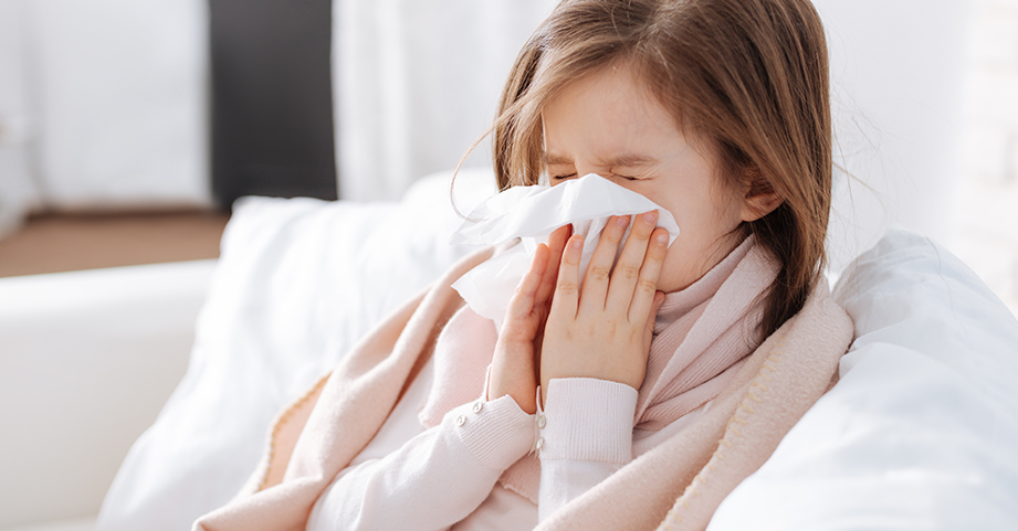 Girl with the flu blowing nose