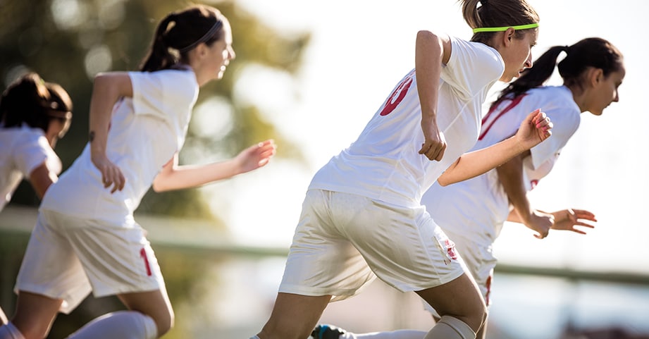 Teen girls playing soccer in the summer