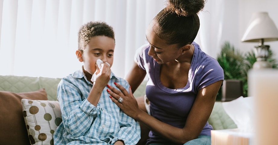 Mom comforting child while wiping his nose