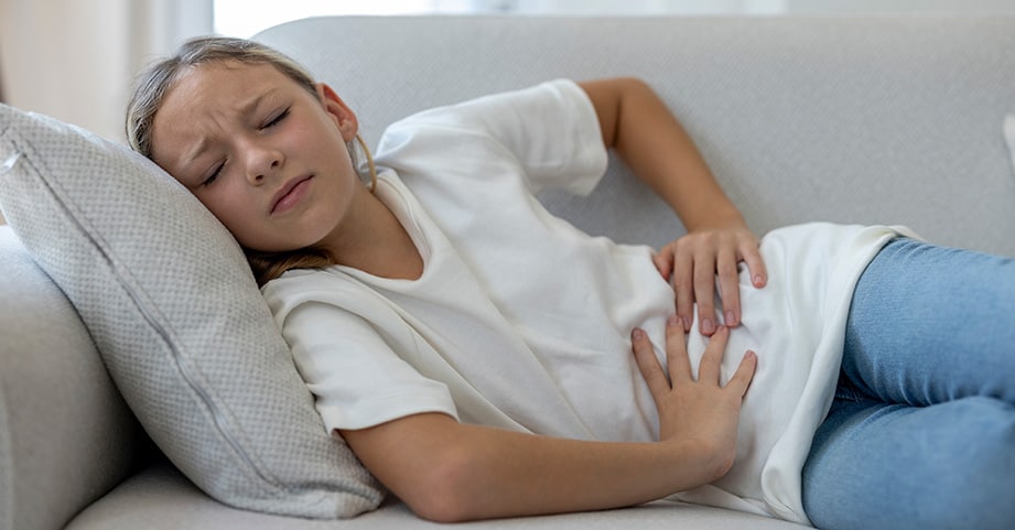 Girl with stomachache laying on the couch