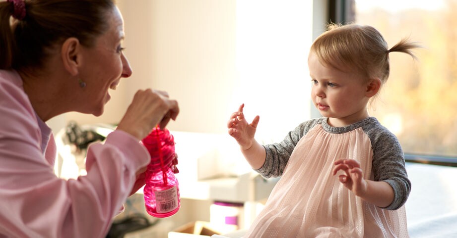 Nurse blowing bubbles to child