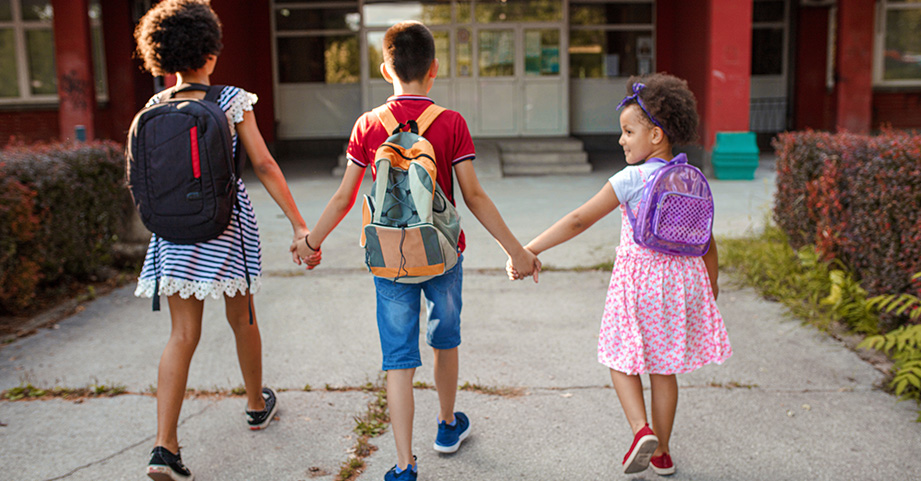 Children walking with backpacks on