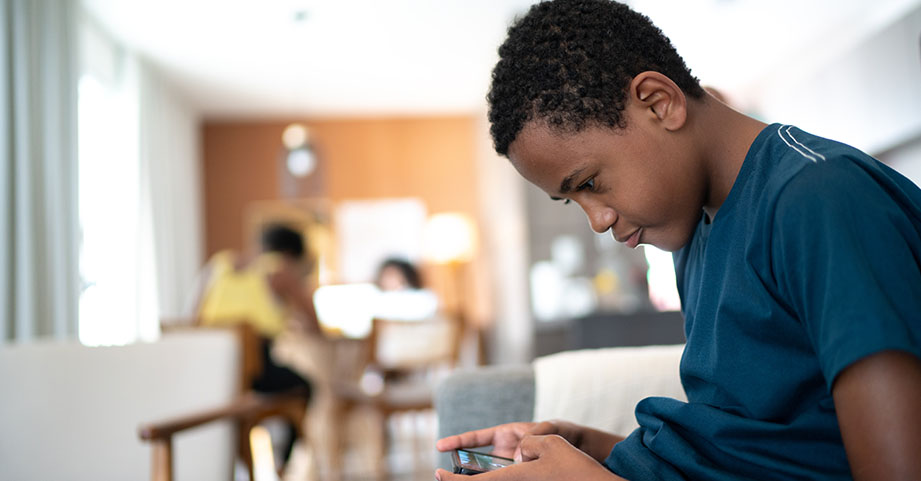 Teen boy playing game on phone