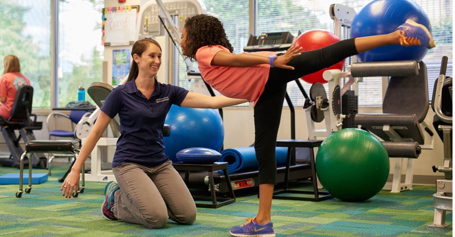 Pediatric sports physical therapist assists teen dancer