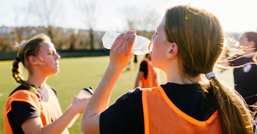 Girl teen athletes drinking water
