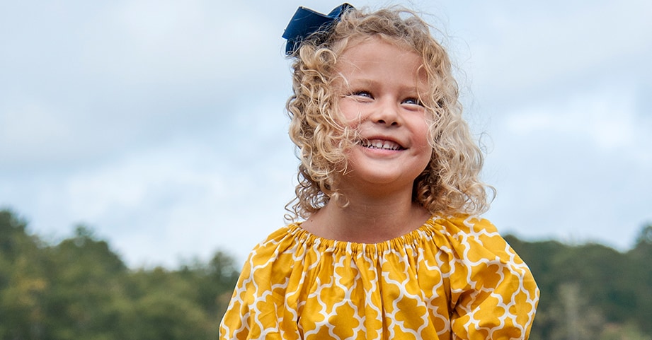 Girl with pediatric c diff smiling with parents