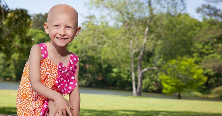 Girl with pediatric cancer smiling in the sun
