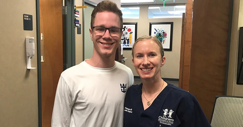 Teen boy with limb foot deformity smiling with pediatric orthopedist