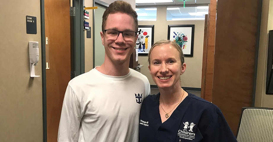 Teen boy with limb foot deformity smiling with pediatric orthopedist