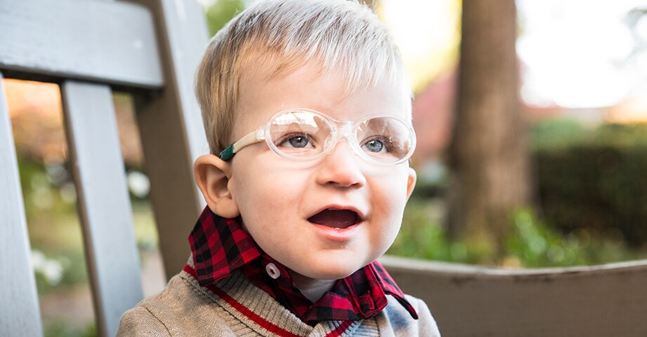 Boy with pediatric neurology condition posing in garden