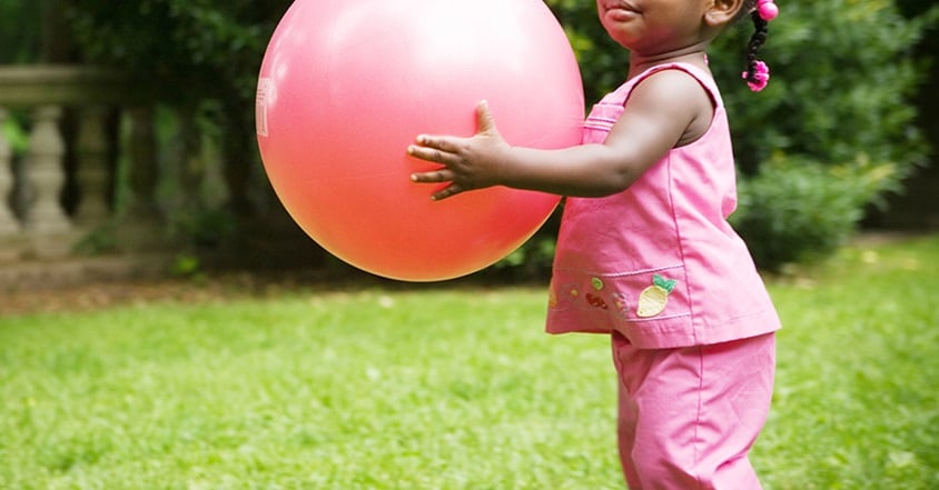 Toddler girl holding a bouncy ball