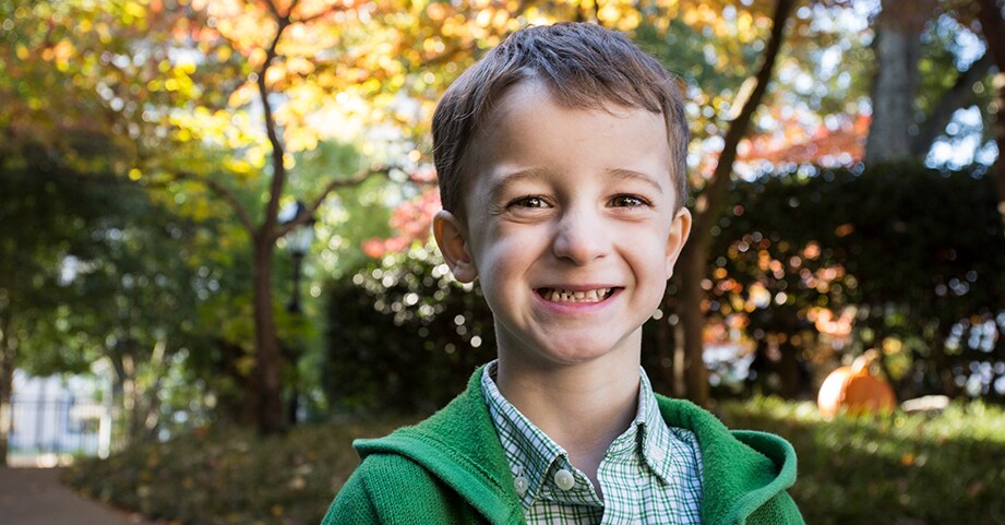 Pediatric heart surgery patient smiling outside hospital