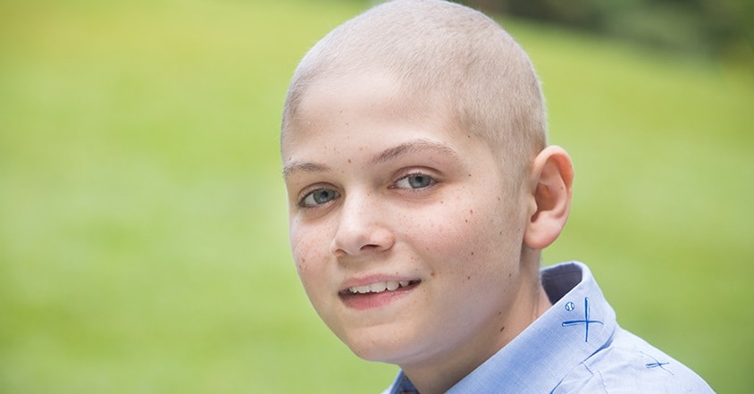 Teen boy with pediatric bone cancer smiling