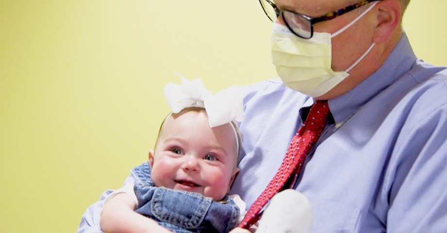 doctor holding smiling baby girl