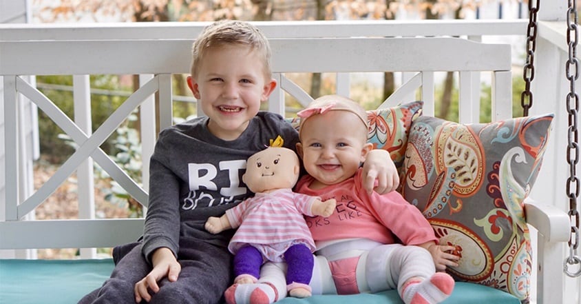 Girl with pediatric hip dysplasia smiling with brother