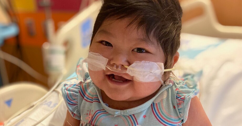 little girl playing in hospital bed