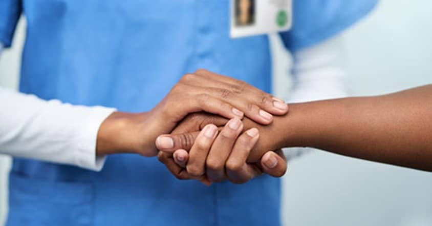 Pediatric nurse holding sickle cell patient's hands