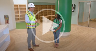former children's patient tours new pediatric hospital wearing hard hat and construction vest