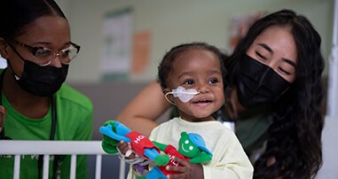 Baby in crib with nurses