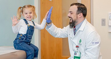 Doctor high fives pediatric patient