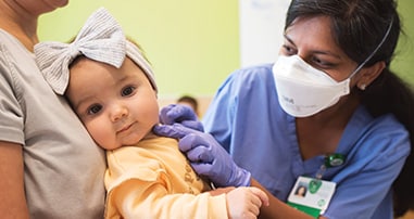 Physician checks infant’s ear during an appointment