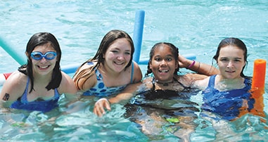 Girls smiling in pool at Camp Carpe Diem