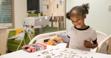 Patient playing with puzzle in pediatric hospital room