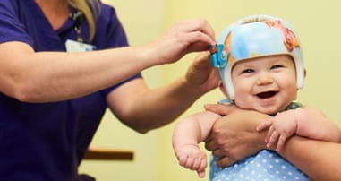 baby being fit with helmet