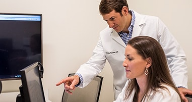 Pediatric Orthopedic doctors reviewing research data on a computer.