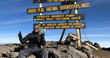 Dr Krish on top of peak in Tanzania