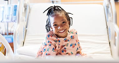 Little girl smiling in hospital bed