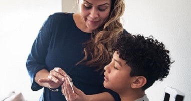 Mom taking temperature of middle school son