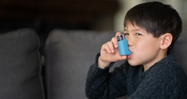Boy with asthma using inhaler